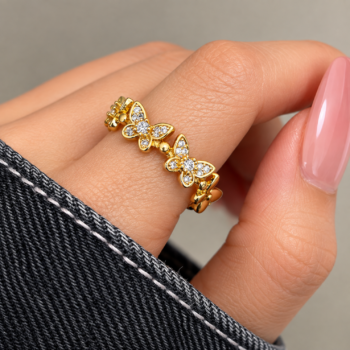 Macro view of pavé-set clear crystals on sculpted butterfly wings with polished bead body accents