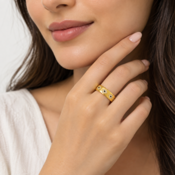 Model wearing Yougorgeous wide gold evil eye cigar band ring styled on index finger