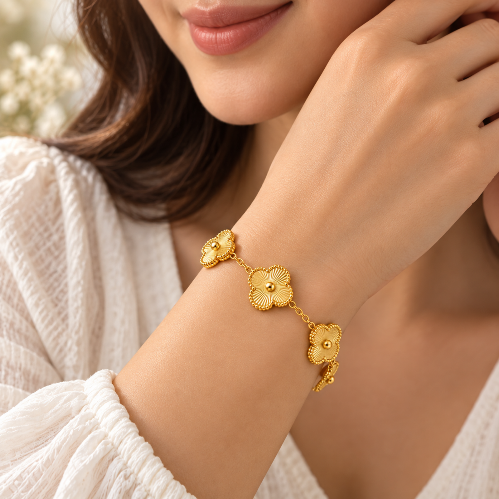 Model wearing Yougorgeous gold guilloche clover bracelet stacked alongside an 18K gold chain Model wearing Yougorgeous gold guilloche clover bracelet stacked alongside an 18K gold chain