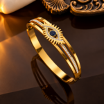 Yougorgeous 18K gold evil eye sunburst hinged bangle with black and clear crystals on white background