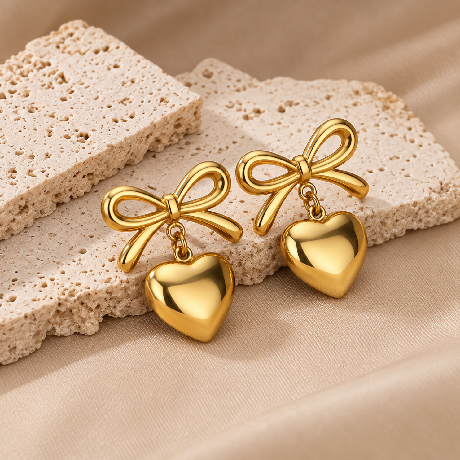 Model wearing Yougorgeous coquette bow and dangling gold heart earrings on lobe Model wearing Yougorgeous coquette bow and dangling gold heart earrings on lobe