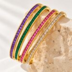 Yougorgeous 18K gold pink crystal tennis bangle with channel set stones on white background