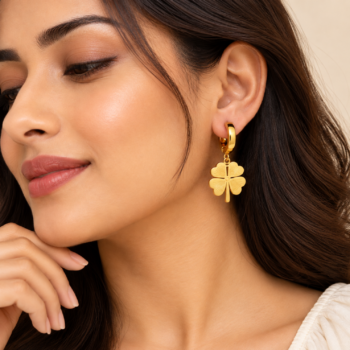 Model wearing Yougorgeous gold clover dangle huggie earrings paired with everyday ear stack